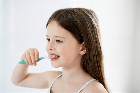 Girl Brushing Teeth in bathroom, close up Stock Photo - Premium Royalty-Free, Code: 693-03557241