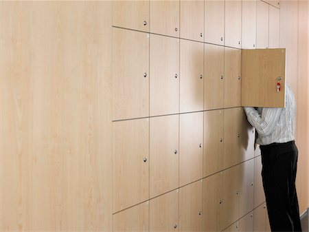 people in panic - Businessman putting head in small locker Stock Photo - Premium Royalty-Free, Code: 693-03557262