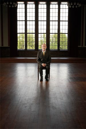 empty room with one person - Businessman Sitting in Large, Empty Room Stock Photo - Premium Royalty-Free, Code: 693-03557360