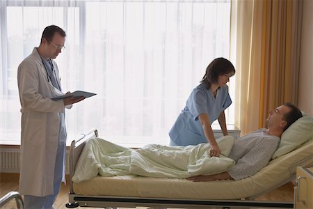 patient standing in hospital room - Infirmière médecin patient réglage dans son lit à l'hôpital Photographie de stock - Premium Libres de Droits, Code: 693-03557527