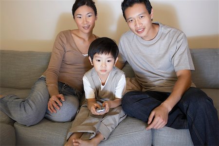 simsearch:693-06016146,k - Couple sitting on sofa, Watching Television while son is using remote control Stock Photo - Premium Royalty-Free, Code: 693-03557632