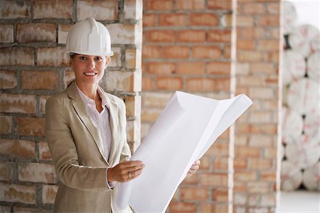 Architect holding plans at construction site Stock Photo - Premium Royalty-Free, Code: 693-03557683