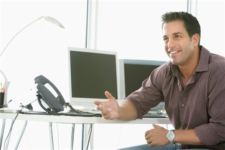 simsearch:693-03307925,k - Businessman smiling by computers in office Fotografie stock - Premium Royalty-Free, Codice: 693-03564413