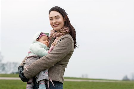 Mother in park, holding sleeping baby girl in arms Stock Photo - Premium Royalty-Free, Code: 693-03564473