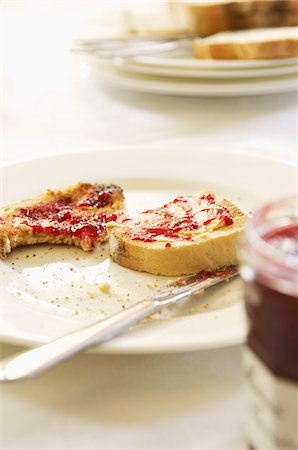 partially eaten - Half-eaten toast with jam on plate with butter knife, close-up Stock Photo - Premium Royalty-Free, Code: 693-03564521