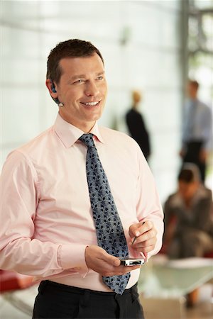 simsearch:693-03307925,k - Businessman Using Wireless Headset and PDA in office Fotografie stock - Premium Royalty-Free, Codice: 693-03564577