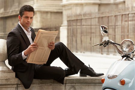 Man sitting by scooter, reading newspaper. Stock Photo - Premium Royalty-Free, Code: 693-03564677
