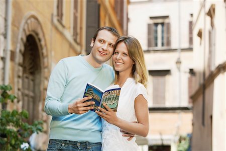 Couple on street in Rome, Italy, holding guidebook, front view Fotografie stock - Premium Royalty-Free, Codice: 693-03564772