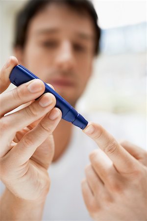 diabetes man - Man using lancelet on finger in bathroom, close up Stock Photo - Premium Royalty-Free, Code: 693-03564889