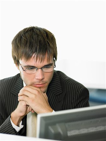 simsearch:693-03565397,k - Serious Businessman looking at computer screen in office Stock Photo - Premium Royalty-Free, Code: 693-03564936