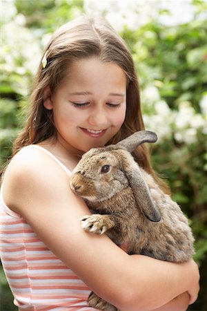 Girl in backyard holding bunny rabbit Foto de stock - Sin royalties Premium, Código: 693-03565021