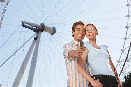 Vacationing Couple Photographing Themselves with mobile phone by London Eye Foto de stock - Sin royalties Premium, Código: 693-03565044