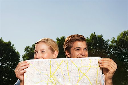 simsearch:693-03302155,k - Lost smiling young couple in park holding map Stock Photo - Premium Royalty-Free, Code: 693-03565043