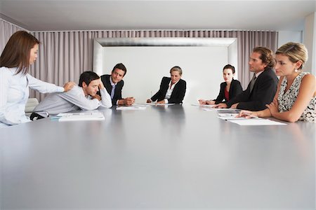 sleeping on boardroom table - Businesswoman Waking Sleeping Colleague During Meeting Stock Photo - Premium Royalty-Free, Code: 693-03565211