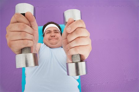simsearch:693-03557462,k - Overweight Man lying down Lifting dumbbells, overhead view Stock Photo - Premium Royalty-Free, Code: 693-03565332