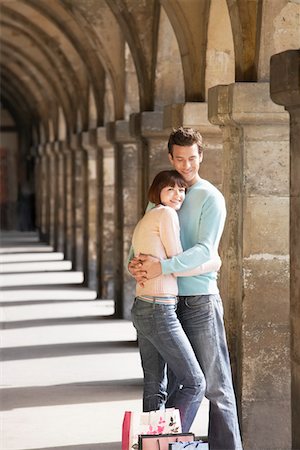 shopping in paris - Couple with shopping bags embracing under archway Stock Photo - Premium Royalty-Free, Code: 693-03565475