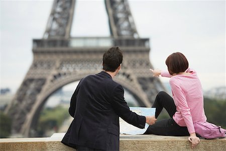 France, Paris, couple looking at map in front of Eiffel Tower, back view Stock Photo - Premium Royalty-Free, Code: 693-03565490