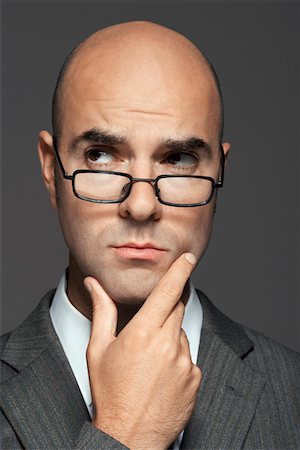 Bald man wearing glasses with hand on chin Stock Photo - Premium Royalty-Free, Code: 693-03565554