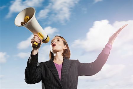 Mid-adult woman shouting through megaphone outside Stock Photo - Premium Royalty-Free, Code: 693-03565576