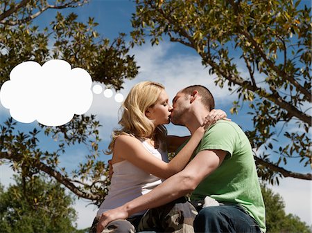 Young couple kissing with think bubble above woman's head Stock Photo - Premium Royalty-Free, Code: 693-03565612