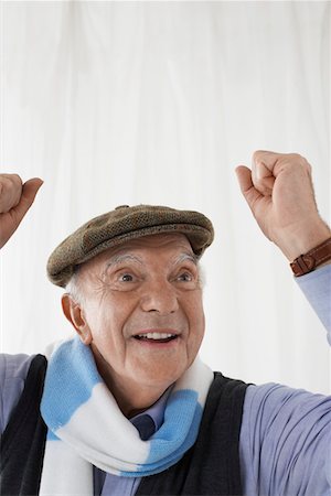flat cap and scarf men - Senior man in football scarf, celebrating in studio, head and shoulders Stock Photo - Premium Royalty-Free, Code: 693-03565633