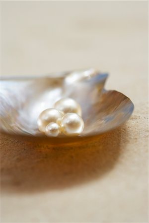 Four pearls in open oyster shell on beach, close up Foto de stock - Sin royalties Premium, Código: 693-03565749