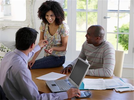 Couple sitting at dining table with financial advisor, elevated view Stock Photo - Premium Royalty-Free, Code: 693-03565770