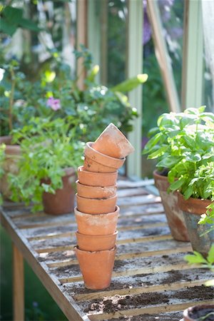 Stack of terracotta flowerpots on workbench in potting shed Stock Photo - Premium Royalty-Free, Code: 693-03617097