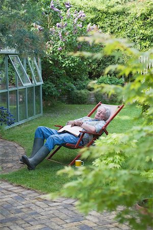 Jardinier dort sur une chaise longue à l'arrière jardin Photographie de stock - Premium Libres de Droits, Code: 693-03617105