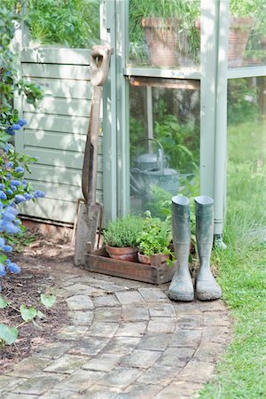 Garden tools and wellington boots outside greenhouse Foto de stock - Sin royalties Premium, Código: 693-03617103