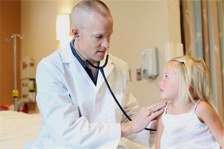 paediatrician (male) - Young pediatrician listens to young girl's breathing Stock Photo - Premium Royalty-Free, Code: 693-03617140
