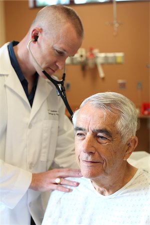 doctor elderly patient - Young doctor listens to young elderly man's breathing Foto de stock - Sin royalties Premium, Código: 693-03617141
