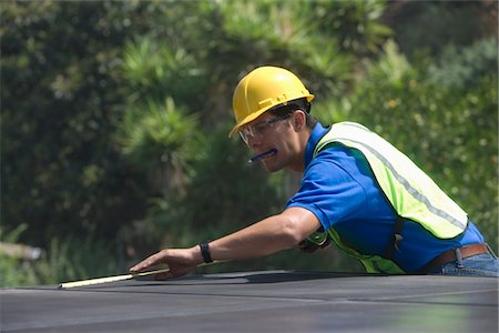 solar power usa - Maintenance worker measures solar array on rooftop, Los Angeles, California Stock Photo - Premium Royalty-Free, Code: 693-03643964