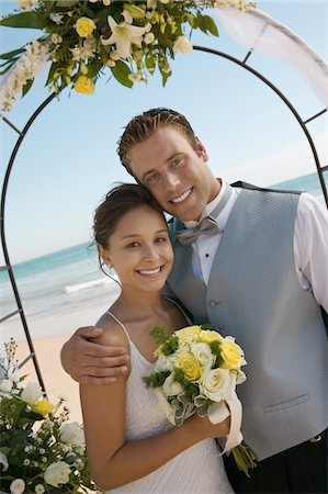 simsearch:693-03686309,k - Bride and Groom under archway on beach, (portrait) Stock Photo - Premium Royalty-Free, Code: 693-03686317