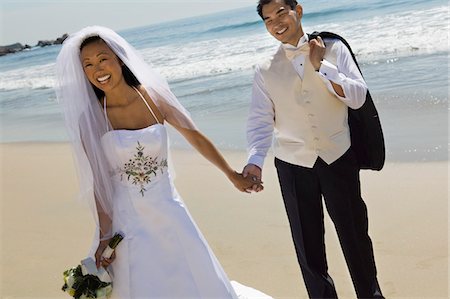 Bride and Groom holding hands on beach Stock Photo - Premium Royalty-Free, Code: 693-03686313