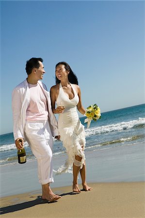 Bride and Groom walking on beach Stock Photo - Premium Royalty-Free, Code: 693-03686321