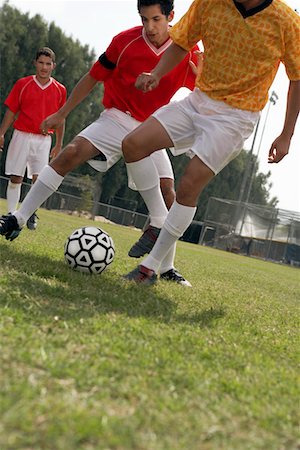 soccer tackle - Soccer players competing for ball, low section Stock Photo - Premium Royalty-Free, Code: 693-03686395