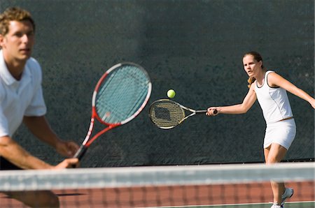 doubles tennis players - Mixed Doubles player hitting tennis ball, partner standing near net Stock Photo - Premium Royalty-Free, Code: 693-03686411