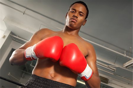 simsearch:614-00657246,k - Boxer avec gants de boxe rouges dans la salle de gym, demi-longueur Photographie de stock - Premium Libres de Droits, Code: 693-03686467