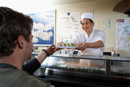 sushi restaurant - Sushi chef handing sushi to customer in restaurant Stock Photo - Premium Royalty-Free, Code: 693-03686488