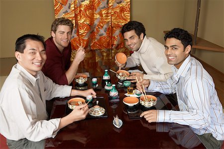 sushi and chop sticks - Young men eating sushi with chopsticks in restaurant Stock Photo - Premium Royalty-Free, Code: 693-03686498