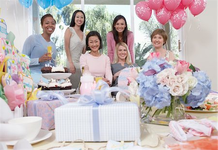 Woman sitting at baby shower behind table of gifts Stock Photo - Premium Royalty-Free, Code: 693-03686531
