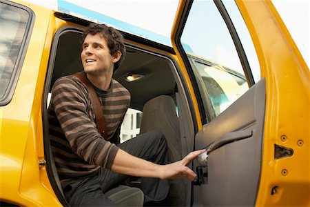 Man exiting taxi in street, low angle view Stock Photo - Premium Royalty-Free, Code: 693-03686578