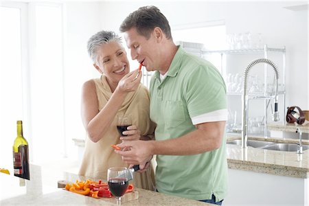 simsearch:614-03763782,k - Woman feeding pepper to husband in kitchen Stock Photo - Premium Royalty-Free, Code: 693-03686594