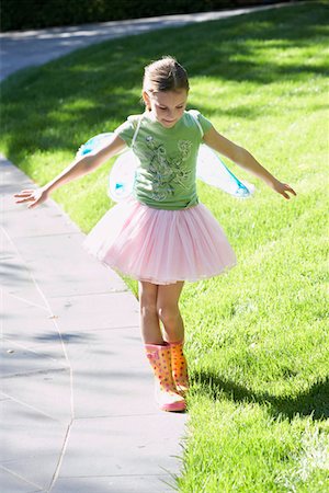 full body of 10 year old girl - Girl wearing fairy wings and tutu balancing on edge of path, portrait Stock Photo - Premium Royalty-Free, Code: 693-03686602