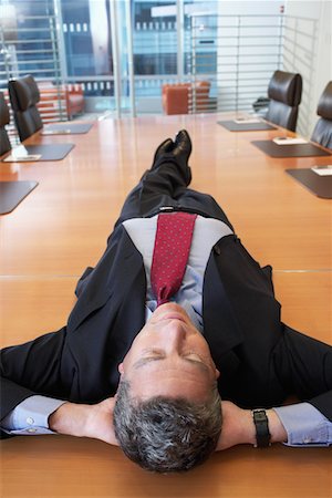 Businessman lying on conference table Stock Photo - Premium Royalty-Free, Code: 693-03686652