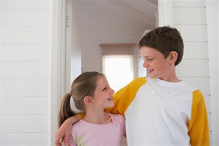 Young boy with arm around girl standing in house, half length Stock Photo - Premium Royalty-Free, Code: 693-03686719