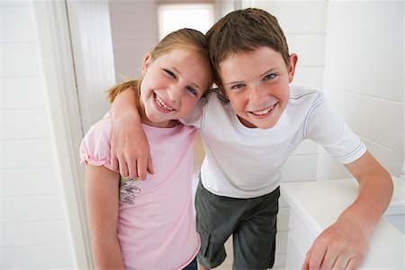 Young boy with arm around young girl in white room Stock Photo - Premium Royalty-Free, Code: 693-03686721