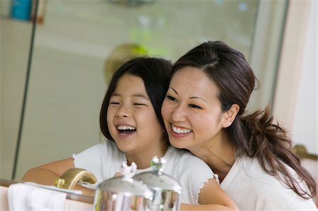Mother and Daughter Looking at reflection in Bathroom mirror, focus on mirror Stock Photo - Premium Royalty-Free, Code: 693-03706933