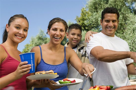 Boy (13-15) with family, gathered around outdoor grill. Foto de stock - Sin royalties Premium, Código de la imagen: 693-03706947